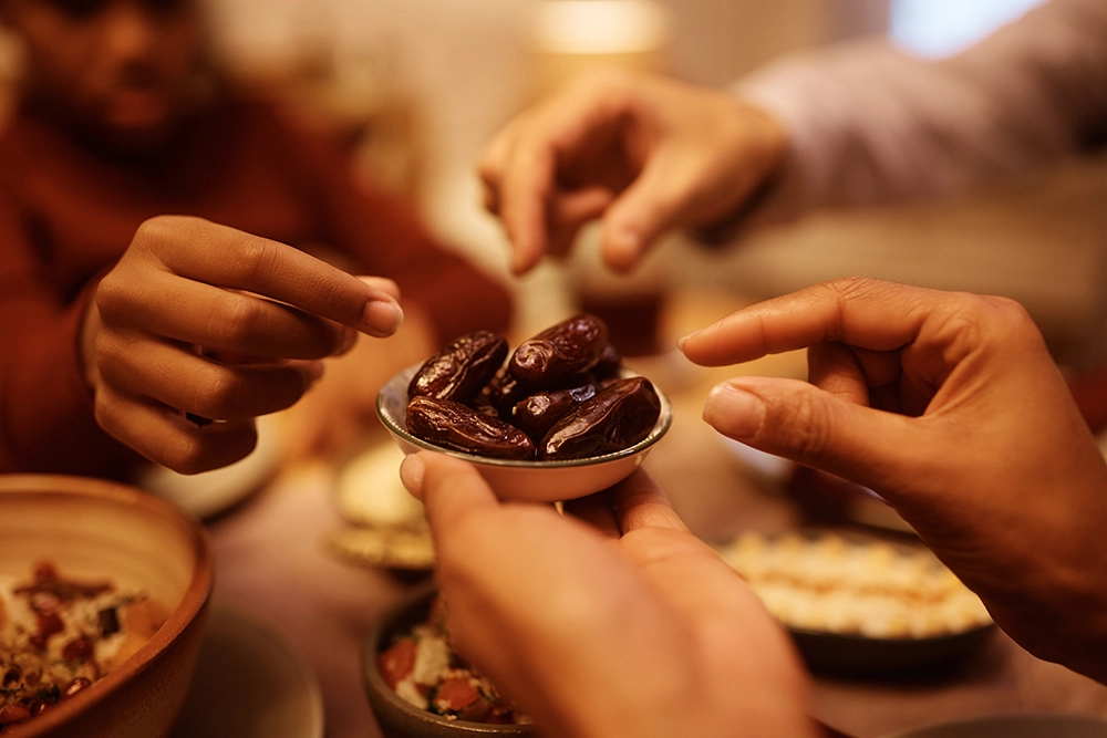 Bu kare, hurmanın aile bağlarını güçlendiren sembolik bir besin olduğunu yansıtır. Umreden hurma getirme geleneğini anlatan bölümde (başlık 4) kullanılabilir. Görsel, “manevi paylaşım” temasını doğrudan destekler.