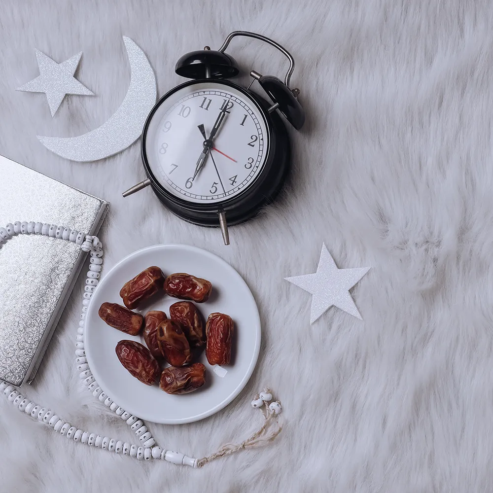 Yumuşak zemin, hilâl ve yıldız detaylarıyla iftar temasını pekiştirir. Hac ve umre yolcularının sahur-iftar düzenine dair “Manevî ve Sağlık Faydaları” bölümüne görsel bağ kurar.

